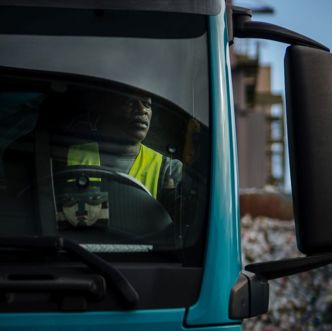 Fahrer sitzt im Führerhaus eines LKWs eines Recyclingunternehmens