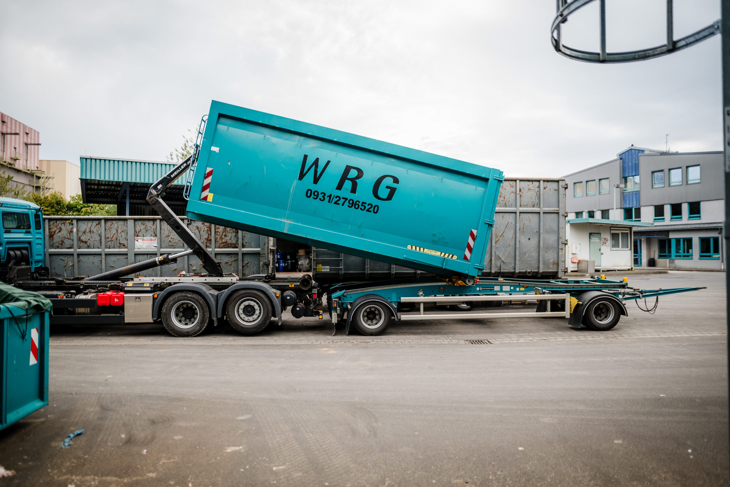 Abrollcontainer wird abgesetzt LKW setzt einen Abrollcontainer auf einem Betriebsgelände ab